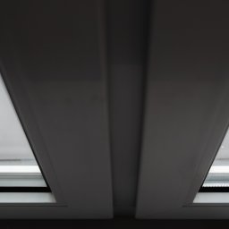 ODNOWA OKNA SPÓŁKA Z OGRANICZONĄ ODPOWIEDZIALNOŚCIĄ - Widok z dołu na białą ramę okienną z szybą, widoczny fragment szarego parapetu zewnętrznego.