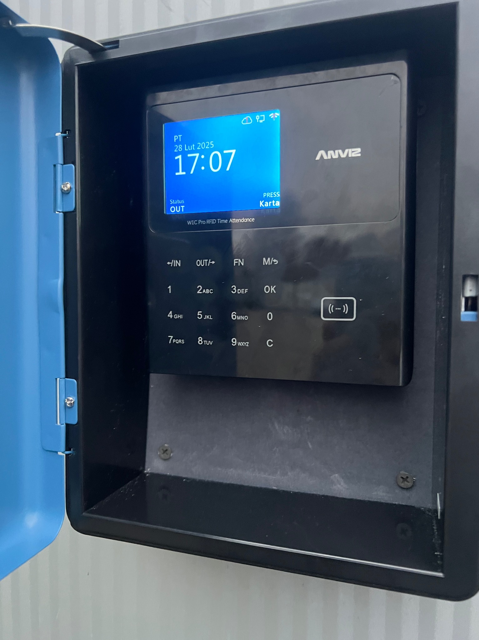 Terminal rejestracji czasu pracy Anviz W1C Pro RFID zamontowany wewnątrz niebieskiej obudowy ochronnej, wyświetlający godzinę 17:07 i datę 28 lutego 2025.