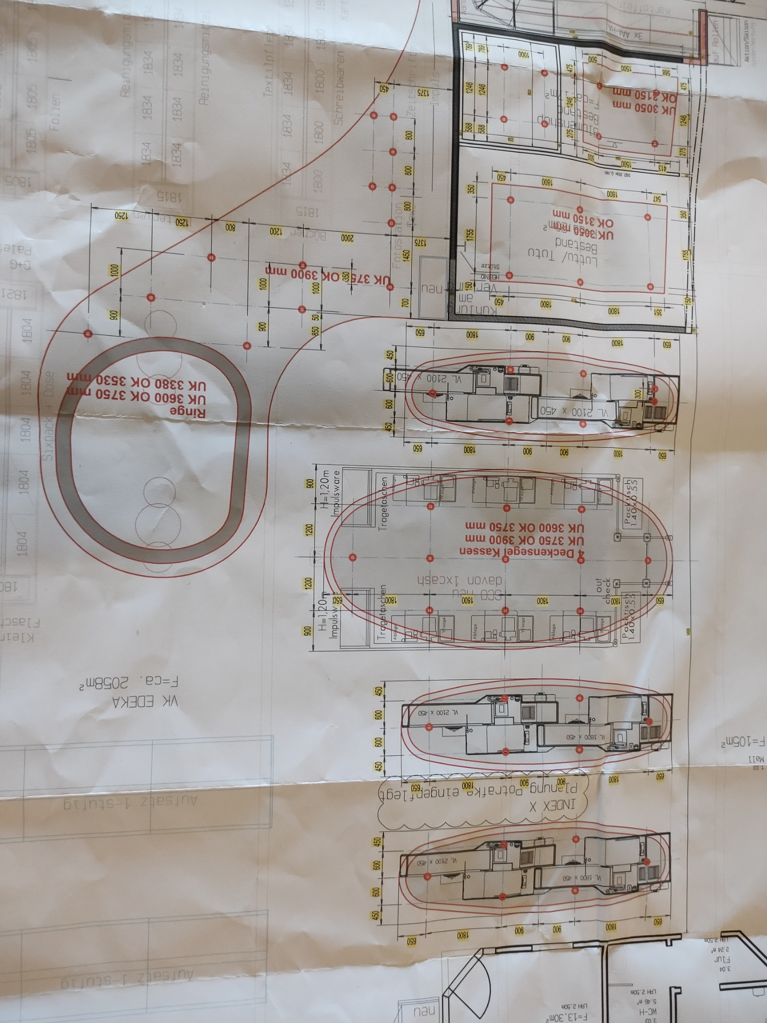 Plan sklepu z zaznaczonymi wymiarami i rozmieszczeniem kas, regałów i innych elementów wyposażenia, widok z góry.
