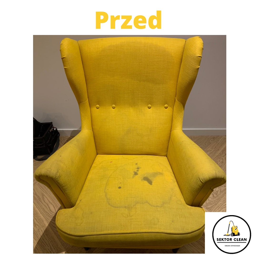 Żółty fotel typu uszak z widocznymi plamami na siedzisku, sfotografowany przed czyszczeniem, z logiem firmy sprzątającej w prawym dolnym rogu.