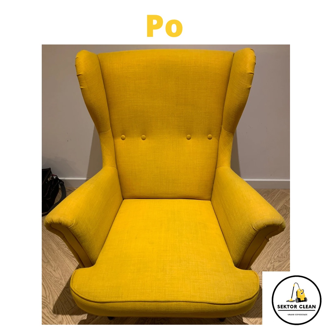 Żółty fotel typu uszak z widocznym napisem 'Po' na górze i logo firmy sprzątającej w prawym dolnym rogu, stojący na drewnianej podłodze.