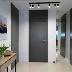 Wysokie, popielate skrzydło z nadstawką do sufitu, zamontowane bez widocznych ościeżnic, w minimalistycznym przedpokoju z bukietem żółtych tulipanów i abstrakcyjnym obrazem na ścianie.