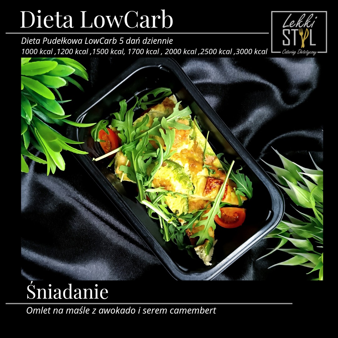 Owsianka z awokado i serem camembert w czarnym pudełku, udekorowana rukolą i pomidorkami koktajlowymi, prezentowana na ciemnym, satynowym tle. Widoczne logo firmy cateringowej w prawym górnym rogu.