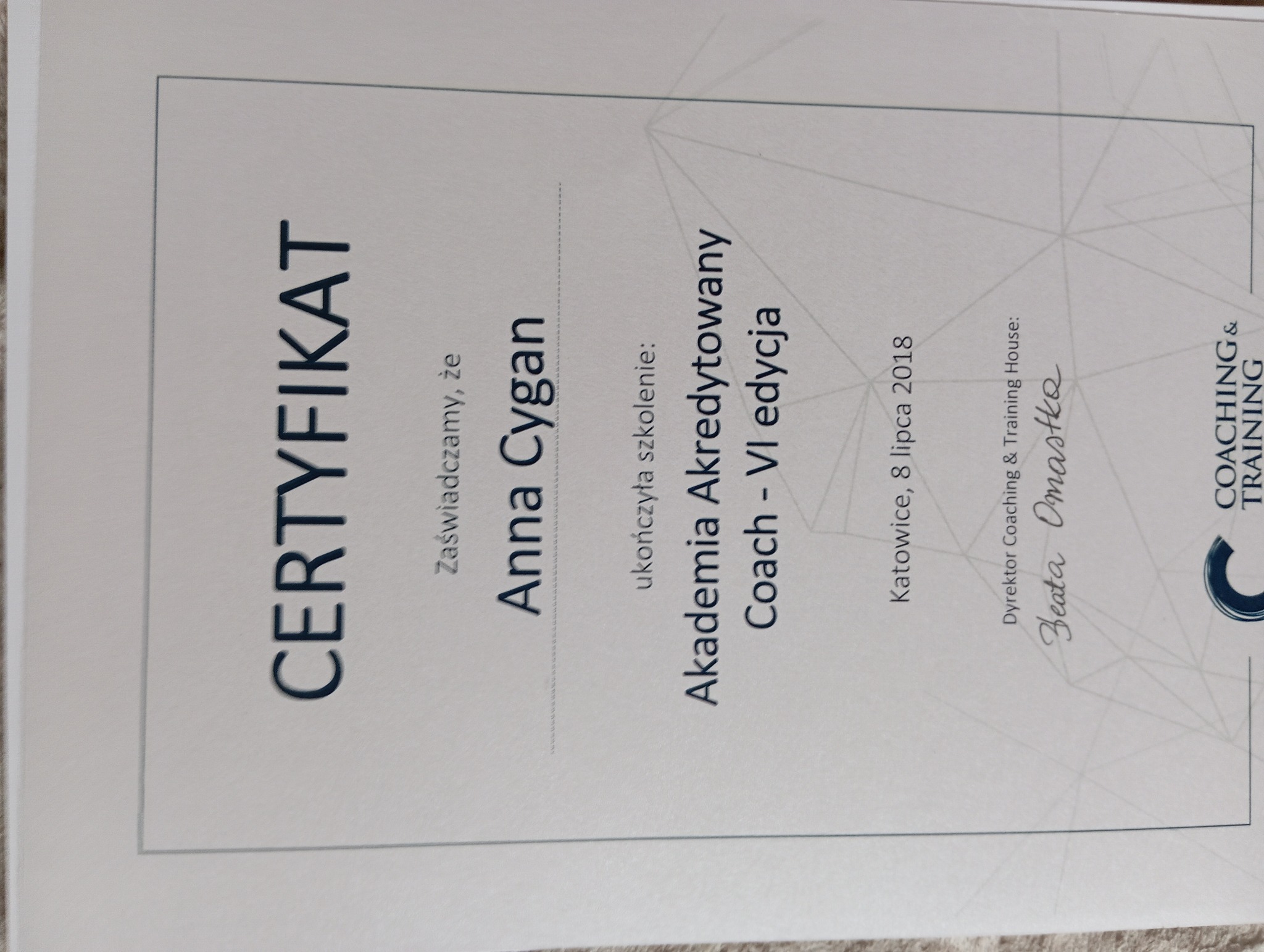 Skan certyfikatu ukończenia szkolenia Akademia Akredytowany Coach - VI edycja przez Annę Cygan, wydany w Katowicach, 8 lipca 2018, podpisany przez dyrektor Coaching & Training House Beatę Omastkę.