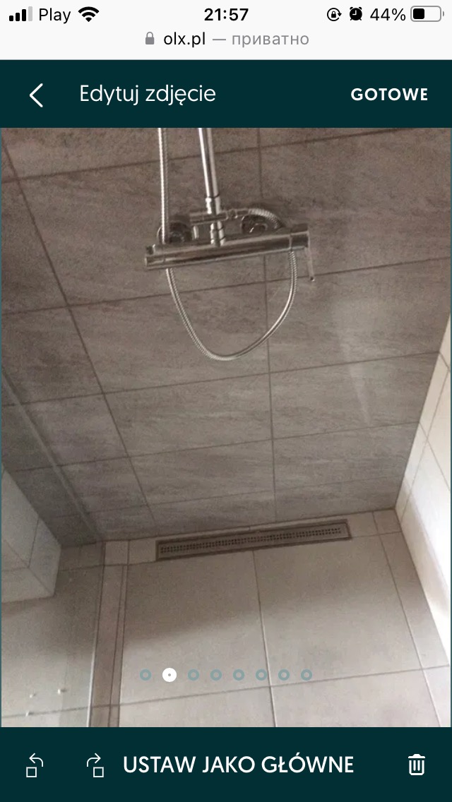 Szare płytki na ścianach i suficie łazienki, widoczny chromowany zestaw prysznicowy z deszczownicą i odpływ liniowy w podłodze, ujęcie od dołu.