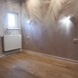 Jasne panele podłogowe w pokoju z tapetą w palmy i białym grzejnikiem. Widoczne gniazdka i lampy ścienne.