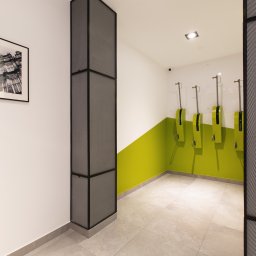 Vrestpoint - Nowoczesna toaleta publiczna z zielonym akcentem kolorystycznym, dozownikami mydła i czarno-białym zdjęciem budynku w ramce.