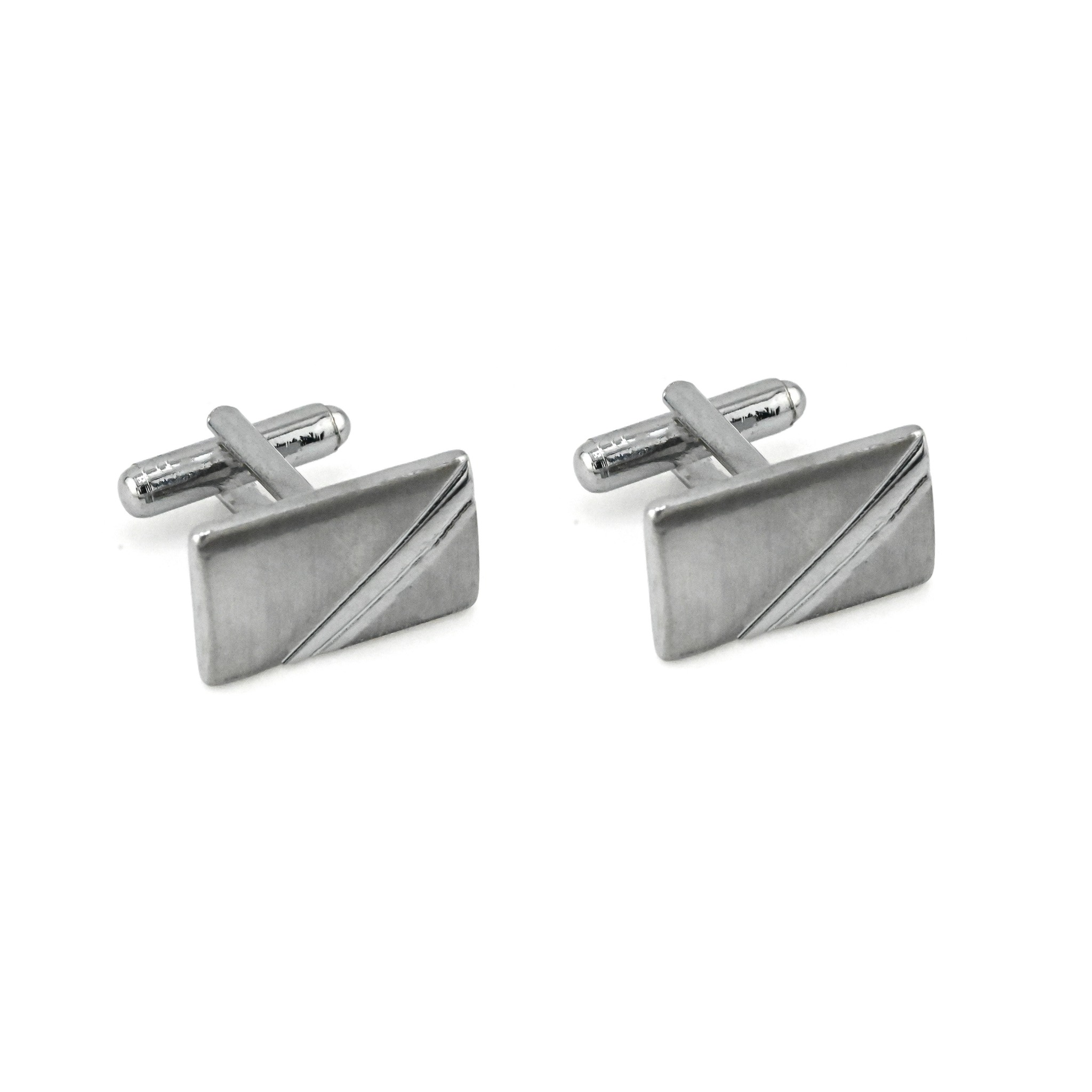 Para srebrnych, prostokątnych spinek do mankietów z ukośnym wzorem na białym tle.