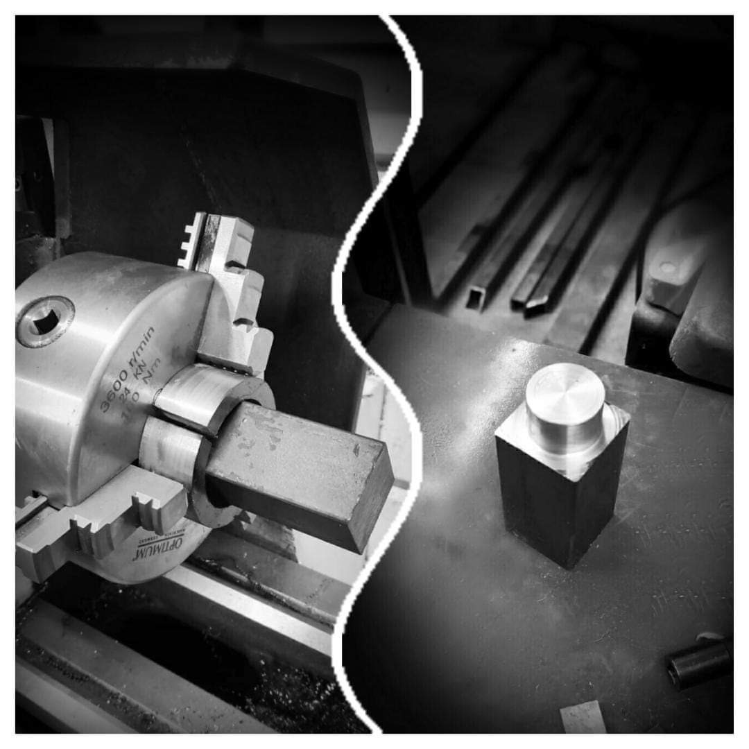 Czarno-białe zdjęcie tokarki z zamocowanym metalowym elementem w uchwycie, obok gotowy element z metalu, w tle widoczne metalowe profile.