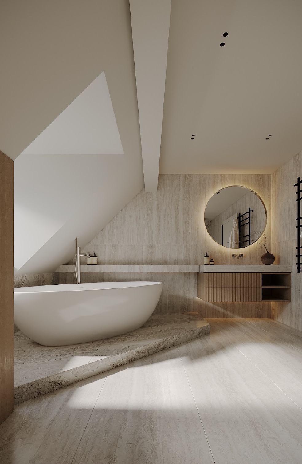 Stylowa aranżacja łazienki na poddaszu w Krakowie. Wolnostojąca wanna, okrągłe lustro z podświetleniem i beżowe płytki imitujące kamień tworzą spójną całość.