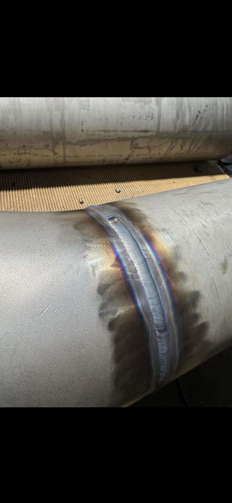 Spoina na rurze ze stali nierdzewnej z widocznymi kolorami hartowania, wykonana metodą TIG.