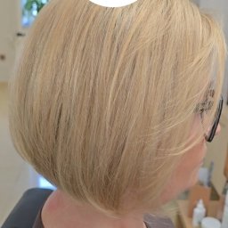 Pracownia Fryzjerska Anny Szanciło - Blond włosy po zabiegu w salonie, widok z tyłu głowy kobiety w okularach. Na dole nazwa i opis produktów My.Organics. W tle logo salonu.