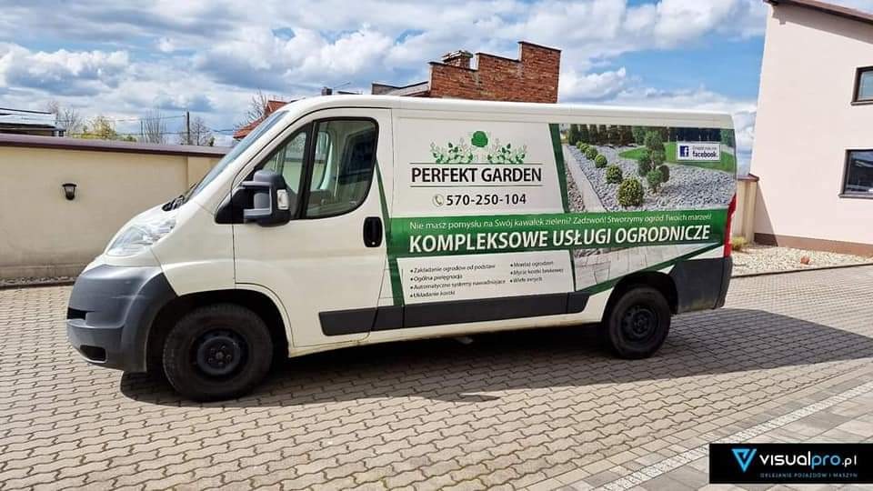 Biały samochód dostawczy z reklamą firmy ogrodniczej Perfekt Garden, prezentujący kompleksowe usługi ogrodnicze, w tym zakładanie ogrodów, ogólną pielęgnację i automatyczne systemy nawadniania.