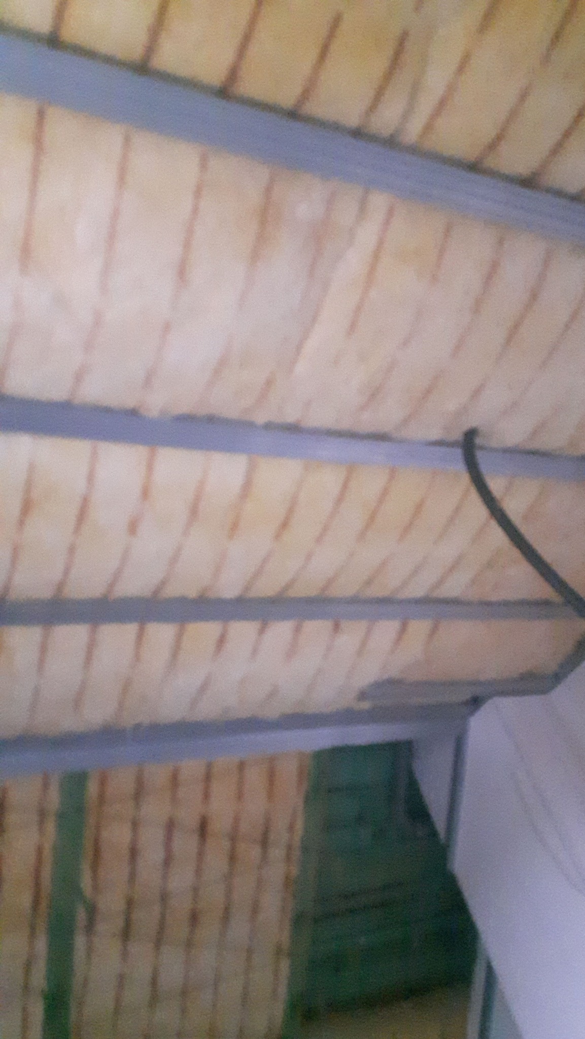 Sufit podwieszany z izolacją w trakcie montażu, widoczne profile i wełna mineralna. Usługi remontowe w Płońsku.