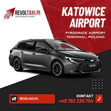 Grafitowy samochód kombi Toyota Corolla z napisem Katowice Airport Pyrzowice Terminal Poland na czerwono-biało-czarnym tle reklamowym z logo firmy RevoltTaxi.pl i numerem telefonu.