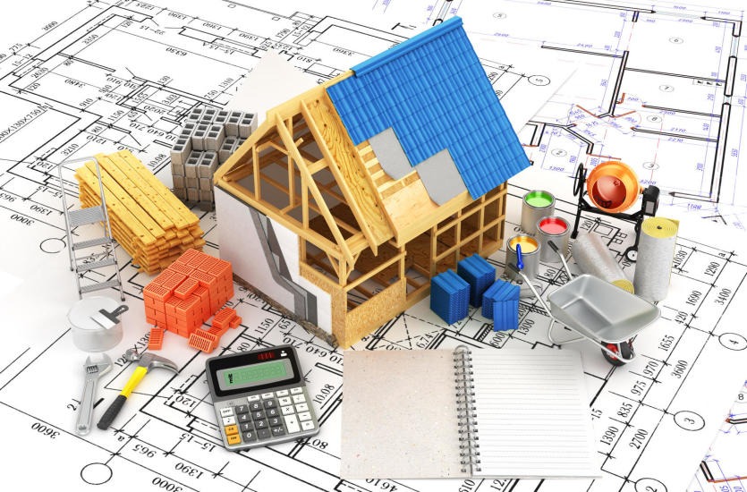 Wizualizacja budowy domu jednorodzinnego: model szkieletu konstrukcji z niebieskim dachem na tle planów architektonicznych, cegły, bloczki, drewno, drabina, mieszarka do betonu, farby, taczka...