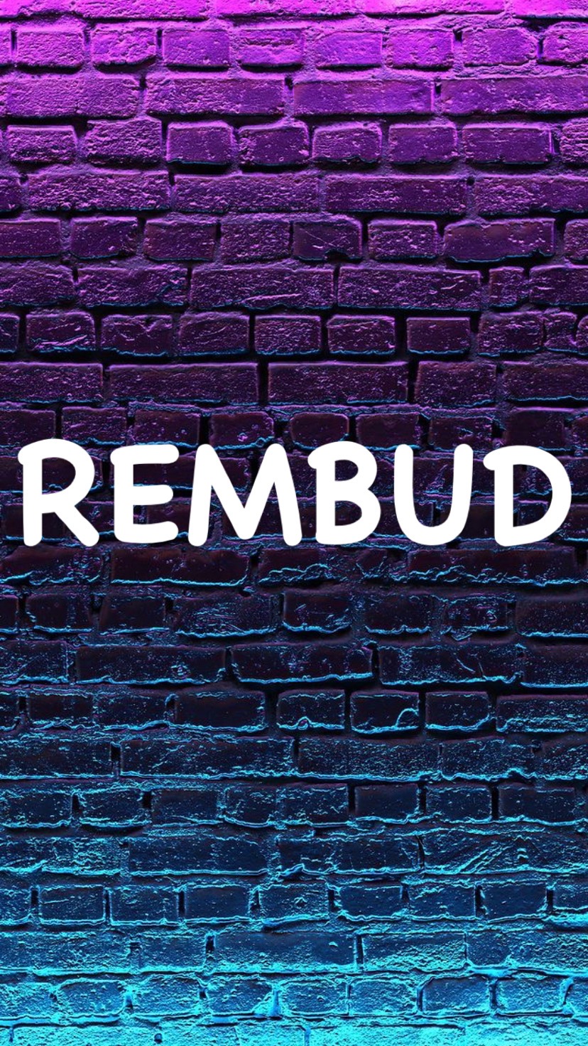 Ceglana ściana z napisem 'REMBUD' w neonowym oświetleniu, gdzie góra ściany ma odcienie fioletu, a dół przechodzi w błękit.