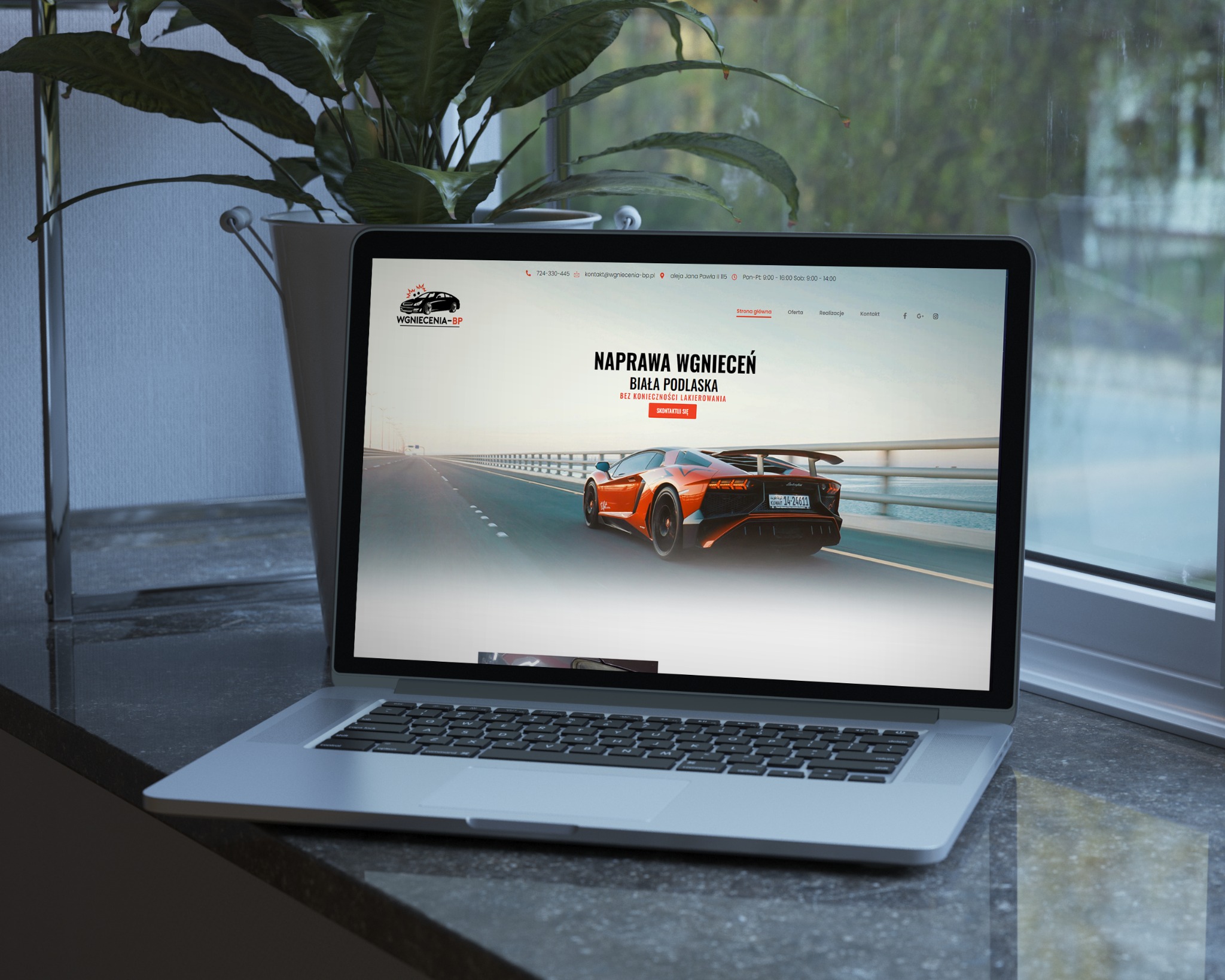 Laptop prezentujący stronę internetową firmy Wgniecenia-BP z Białej Podlaskiej, specjalizującej się w naprawie wgnieceń bez konieczności lakierowania. Na ekranie widoczny pomarańczowy samochód...