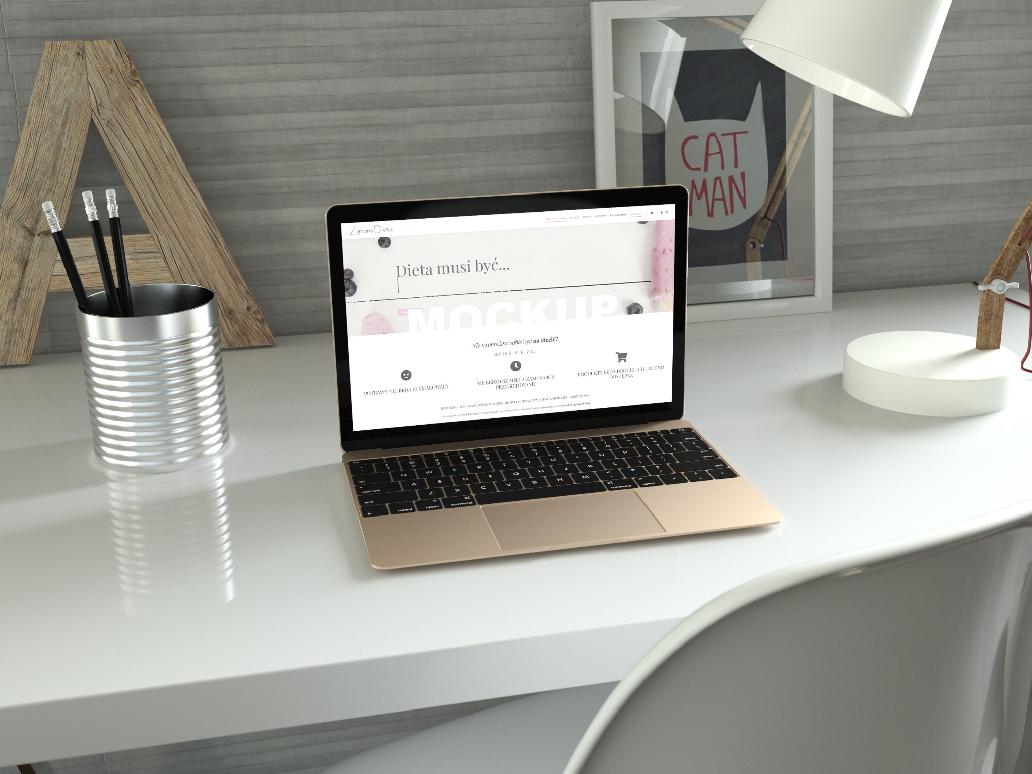 Laptop z otwartą stroną internetową o tematyce dietetycznej na białym biurku, obok metalowy pojemnik z ołówkami, lampka i grafika 'Cat Man' w ramce.