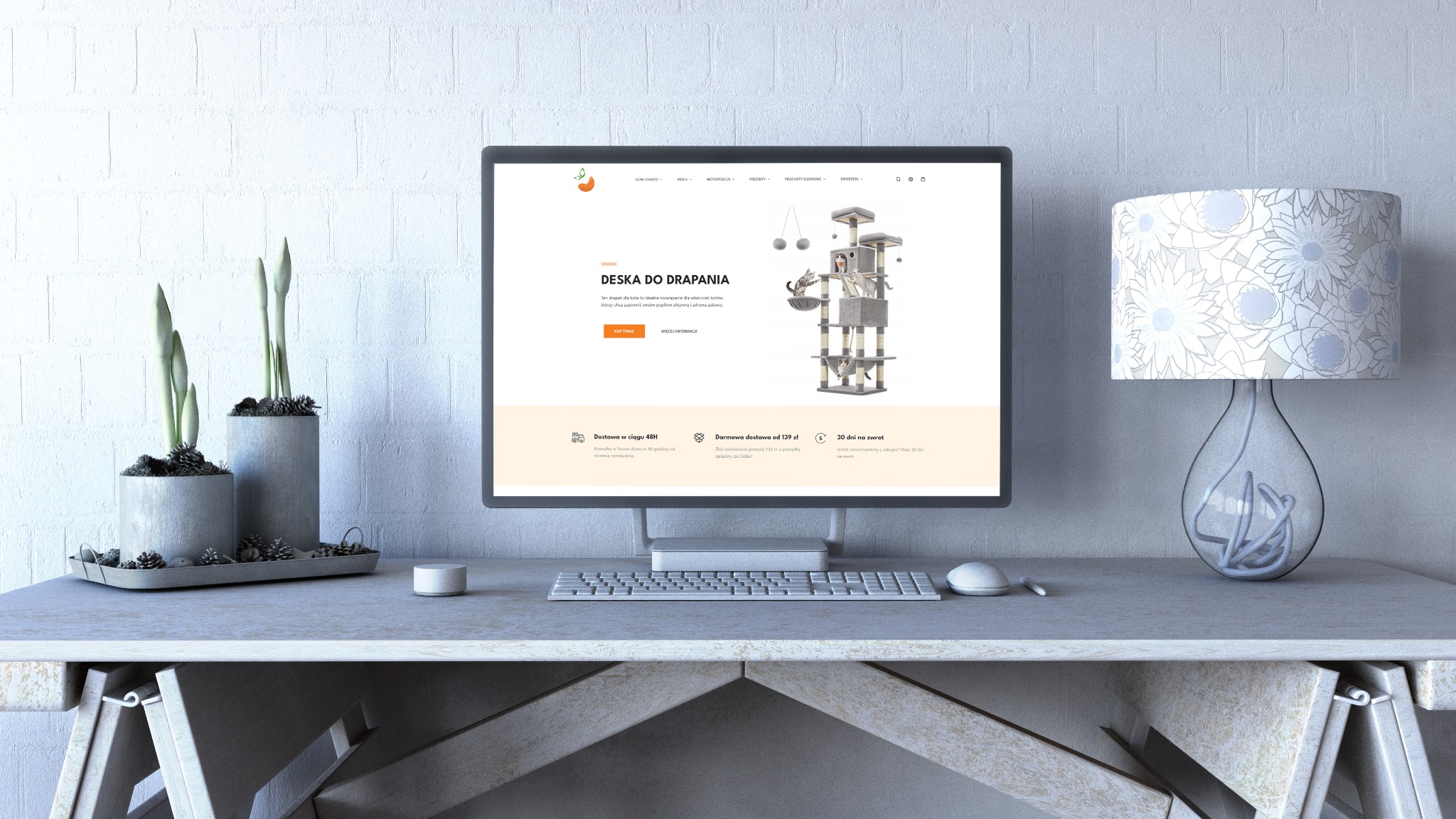 Monitor wyświetlający stronę internetową z ofertą drapaka dla kota, ustawiony na biurku z dekoracjami w stonowanych kolorach.