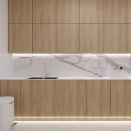 Nowoczesna łazienka z drewnianymi szafkami, marmurowym blatem i podświetleniem LED pod szafkami oraz nad blatem, widoczny fragment toalety.