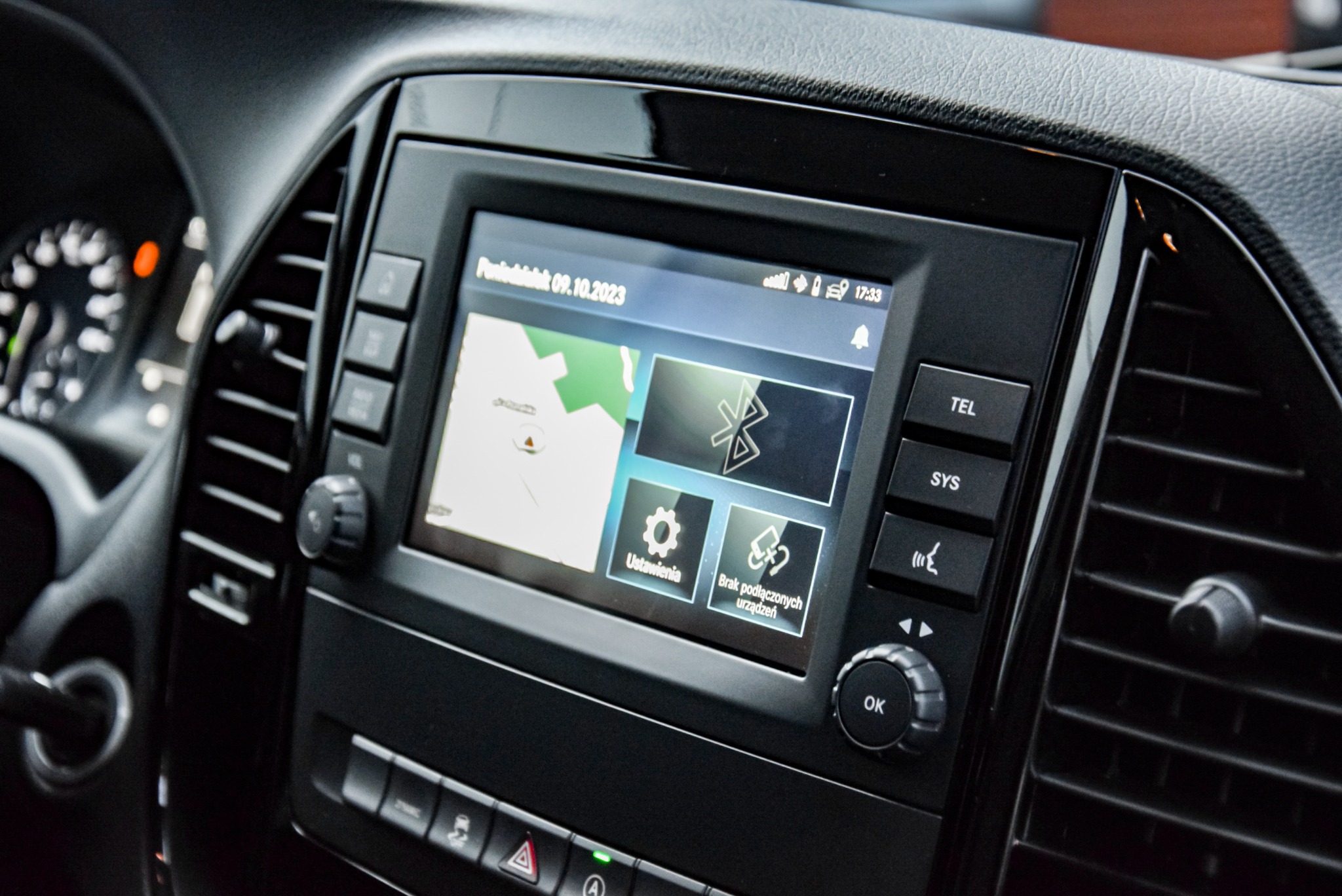Deska rozdzielcza samochodu z widocznym ekranem nawigacji i systemem Bluetooth, z datą 09.10.2023.