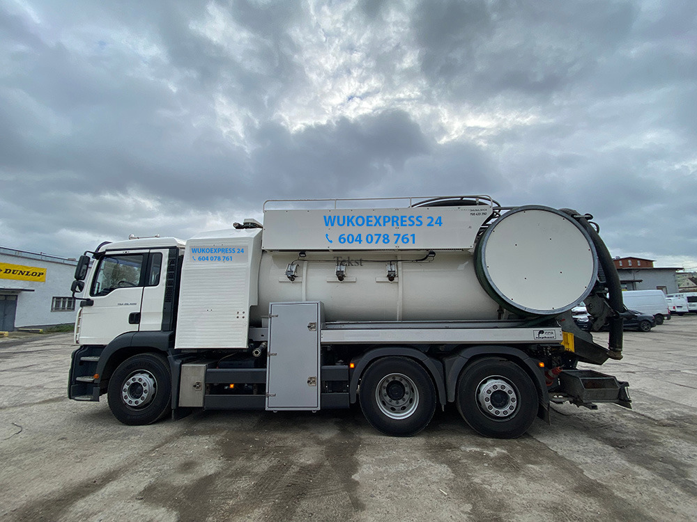 Ciężarówka WUKOEXPRESS 24 z numerem telefonu 604 078 761, przeznaczona do czyszczenia kanalizacji, zaparkowana na betonowym placu pod pochmurnym niebem.