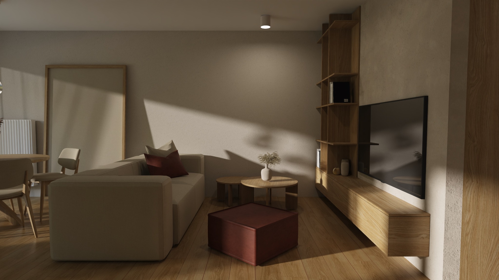 Jasne wnętrze salonu z drewnianą podłogą, beżową sofą z czerwoną poduszką, okrągłymi stolikami kawowymi, pufą i regałem z telewizorem, oświetlone naturalnym światłem padającym z okna.