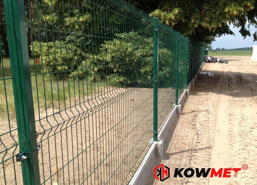 Zielone ogrodzenie panelowe z podmurówką betonową, widoczne z boku, z logo firmy w prawym dolnym rogu.