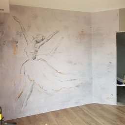 Paulina Skalny Skalbud - Ściana z dekoracyjnym malunkiem baletnicy w bieli i szarości, widoczny laser krzyżowy, drewniana podłoga, kącik z drabinką w tle.