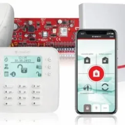 Panel sterowania alarmem z ekranem dotykowym, centrala alarmowa z czerwoną płytą główną, czujnik ruchu oraz smartfon z aplikacją MySolid prezentującą interfejs sterowania systemem alarmowym.