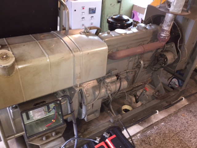 Agregat prądotwórczy z widoczną obudową, filtrem powietrza oraz elementami elektrycznymi w skrzynce przyłączeniowej.