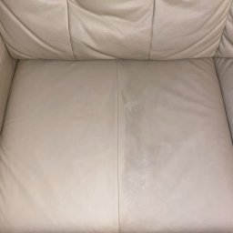 Czysty Sen pranie tapicerki w Lublinie - Jasna skórzana kanapa z widoczną różnicą w czystości połowy siedziska, prezentująca efekt przed i po czyszczeniu.