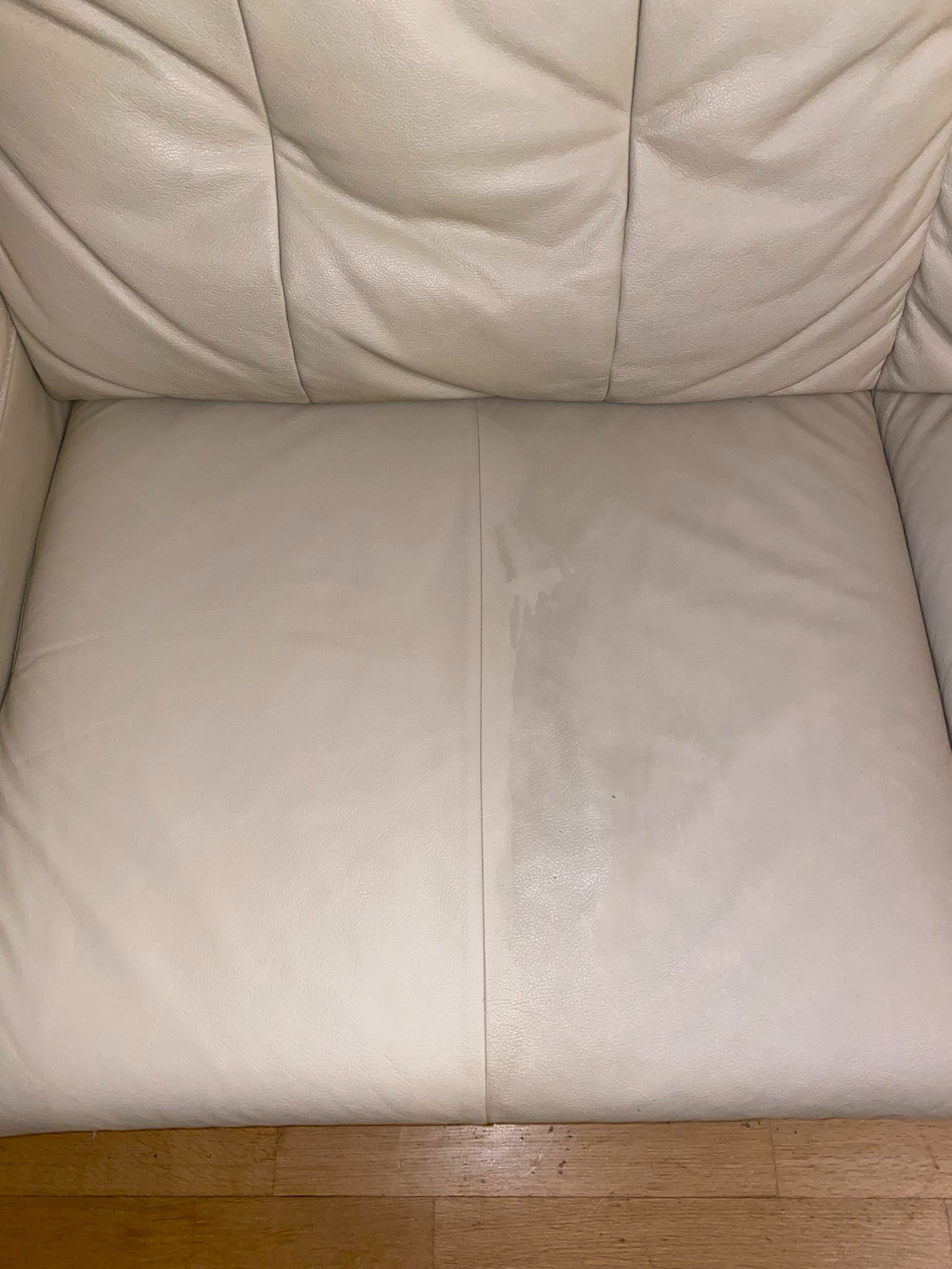 Jasna skórzana kanapa z widoczną różnicą w czystości połowy siedziska, prezentująca efekt przed i po czyszczeniu.