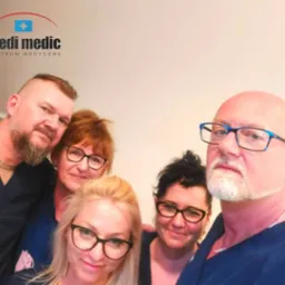Grupowe selfie zespołu medycznego w uniformach, z widocznym logo placówki 'medi medic' w lewym górnym rogu.