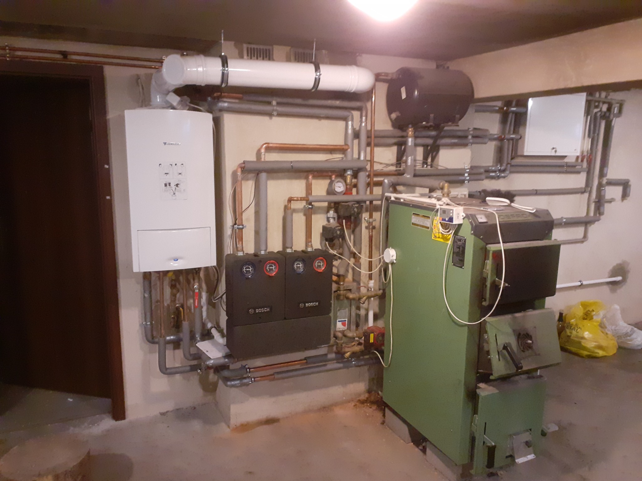 Kotłownia z kotłem na paliwo stałe, zasobnikiem ciepłej wody, kotłem gazowym Vaillant i rozbudowaną instalacją hydrauliczną z rur miedzianych i szarych PCV.