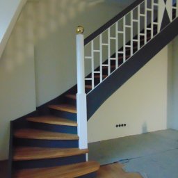 Usługi Stolarsko ślusarskie Franciszek Miszczak - Drewniane schody z balustradą o geometrycznym wzorze w Mościcach. Stopnie w odcieniach brązu, kontrastujące z ciemną konstrukcją i białymi elementami.