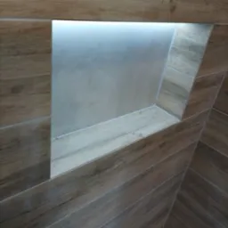 Narożna wnęka z podświetleniem LED w łazience wyłożonej płytkami imitującymi drewno, ułożonymi w jodełkę.