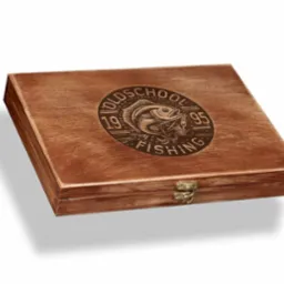 Drewniane pudełko z wygrawerowanym logo wędkarskim 'Oldschool Fishing 1995' i metalowym zapięciem, leżące na białym tle.