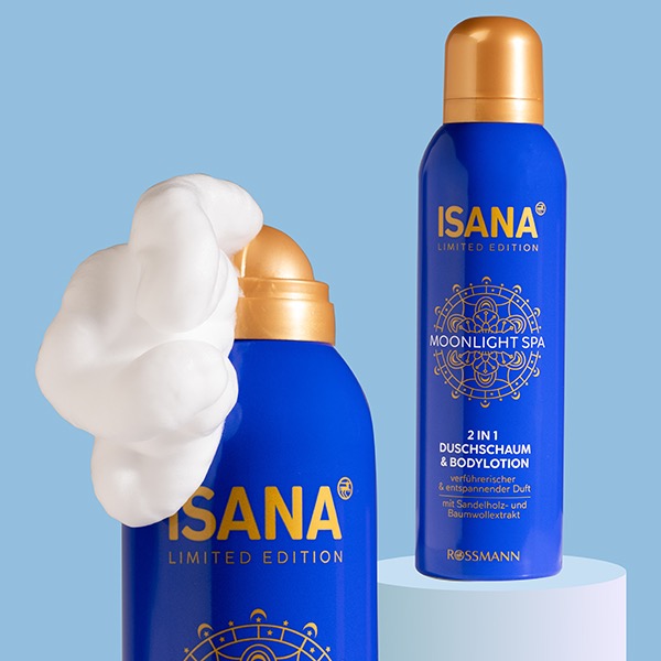 Dwa niebieskie pojemniki z pianką do kąpieli i balsamem Isana Moonlight Spa Limited Edition na jasnoniebieskim tle, jeden z pianką wydobywającą się z dozownika.