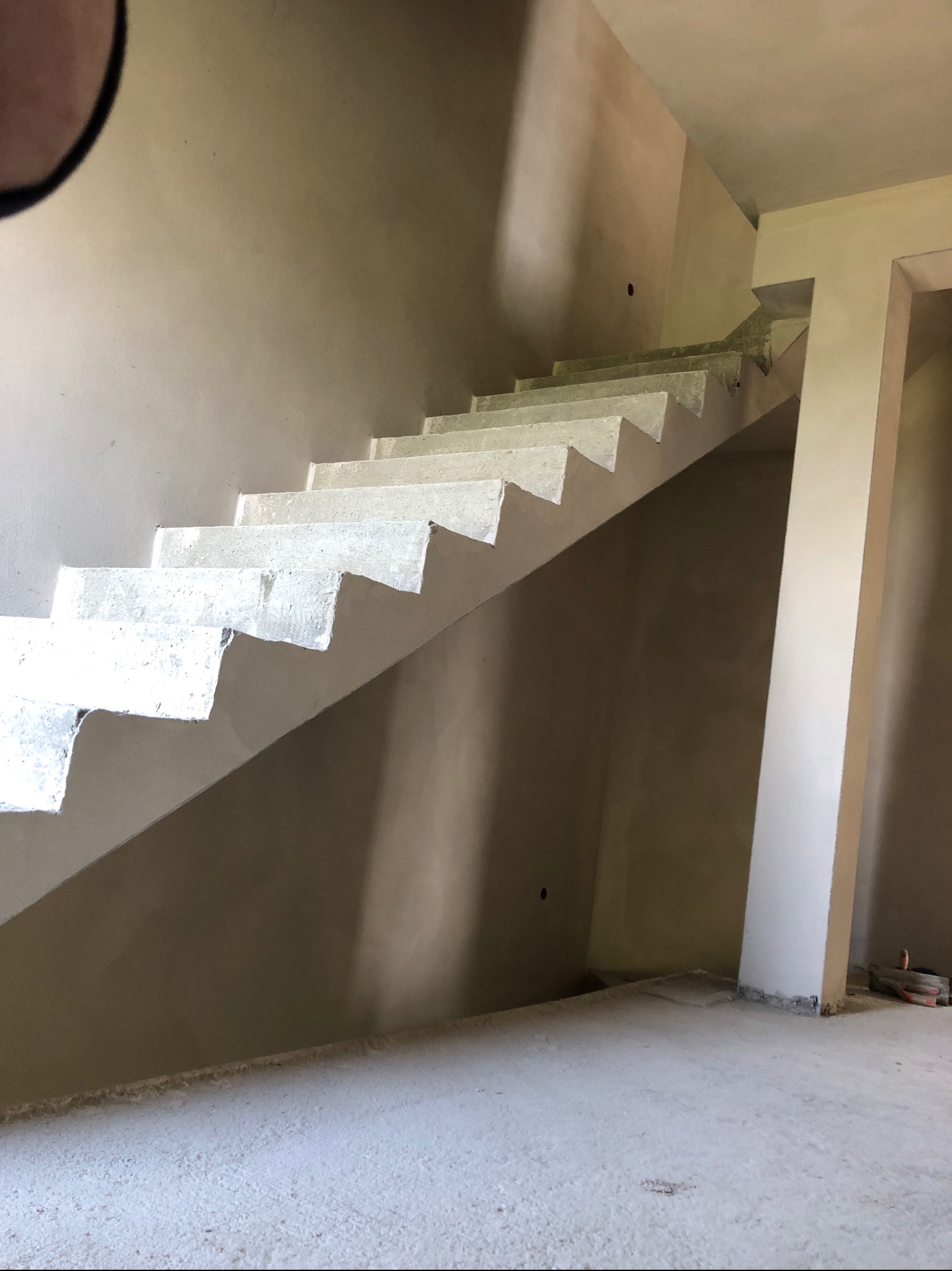 Surowe betonowe schody w trakcie budowy w Żywcu, widoczne ściany przygotowane pod tynk.