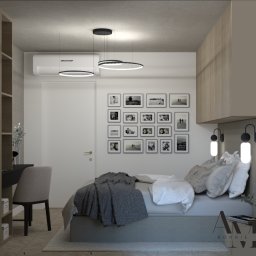 BonnieAM ALEKSANDRA MIKOŁAJCZYK - Wizualizacja sypialni z łóżkiem, biurkiem i galerią czarno-białych zdjęć na ścianie, oświetlona wiszącymi lampami pierścieniowymi i kinkietami przy łóżku, z klimatyzatorem nad drzwiami.