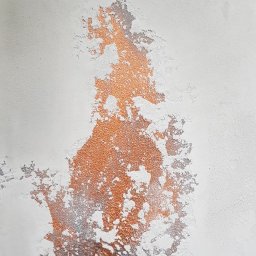 Styloteka - Dekoracyjna ściana z efektem miedzi i przetarć w odcieniach szarości na jasnym tle, ukazująca nieregularną teksturę.