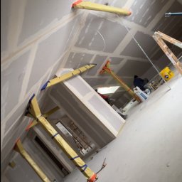 Usługi ogólnobudowlane - Skośne ujęcie poddasza z zamontowanymi płytami gipsowo-kartonowymi, widoczne profile i podpory montażowe. Prace wykończeniowe w trakcie realizacji.