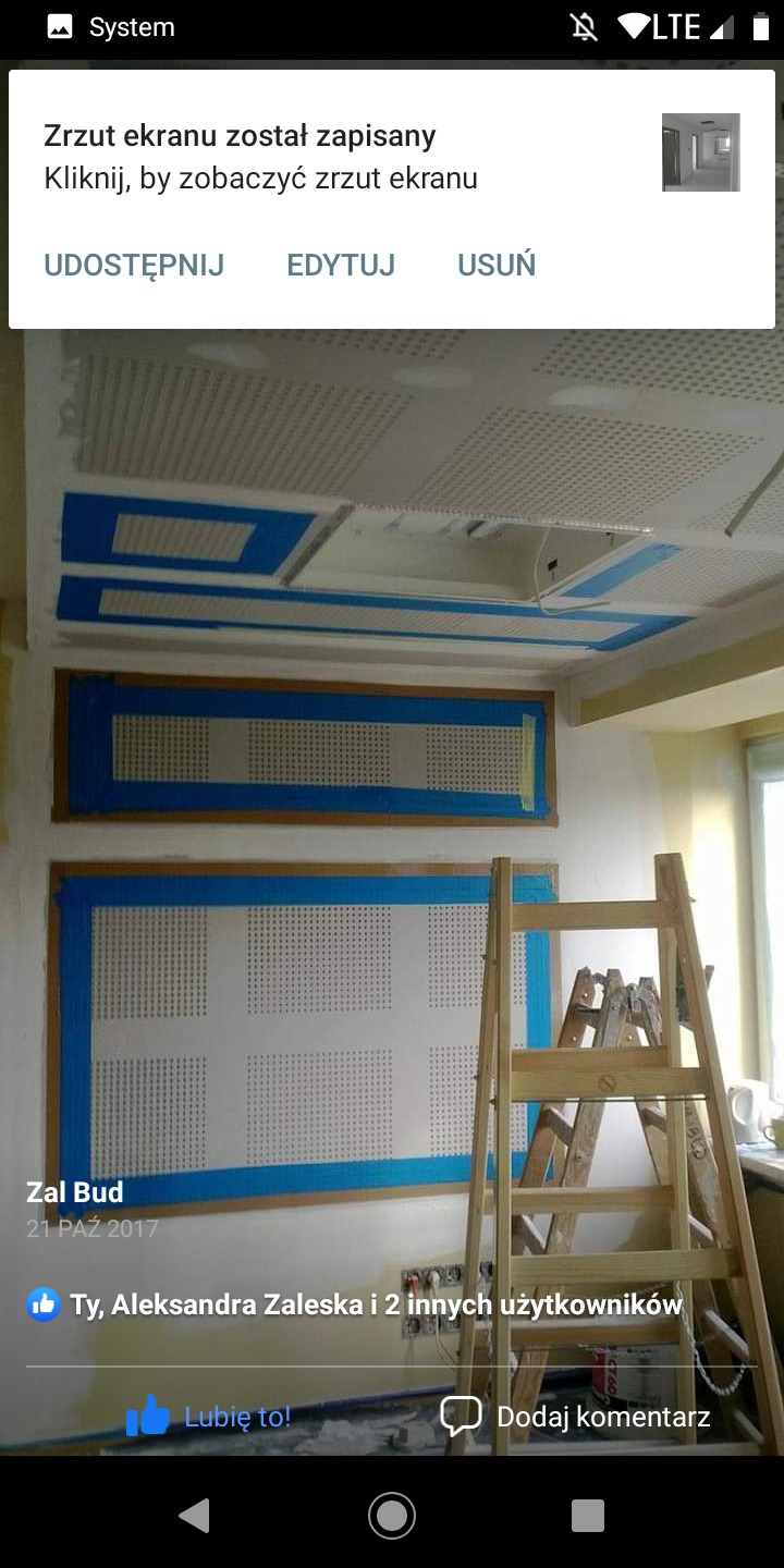 Przygotowania do prac wykończeniowych w pomieszczeniu biurowym: zabezpieczone taśmą perforowane panele ścienne i sufitowe, drewniana drabina w tle.