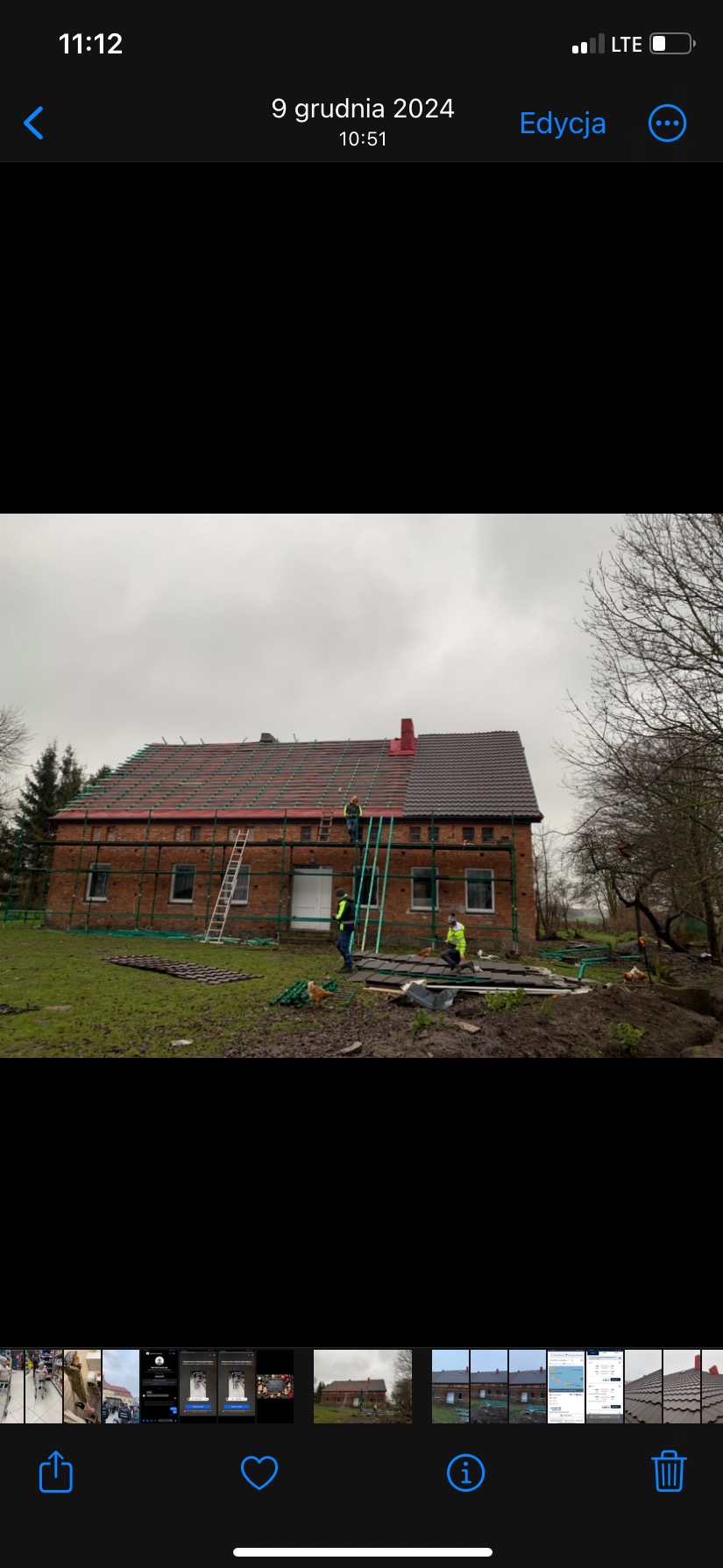 Ekipa budowlana w Darłowie podczas prac na dachu ceglanego domu, widoczne rusztowania, drabiny i częściowo położone nowe pokrycie.