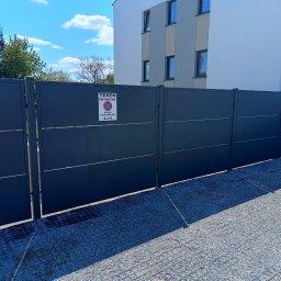DB.Building Dominik Budzyński Usługi Wypożyczalnia - Nowoczesne, grafitowe ogrodzenie panelowe z tabliczką informacyjną 'Teren prywatny' na tle jasnego budynku i nieba. Widoczna nawierzchnia z kruszywa.