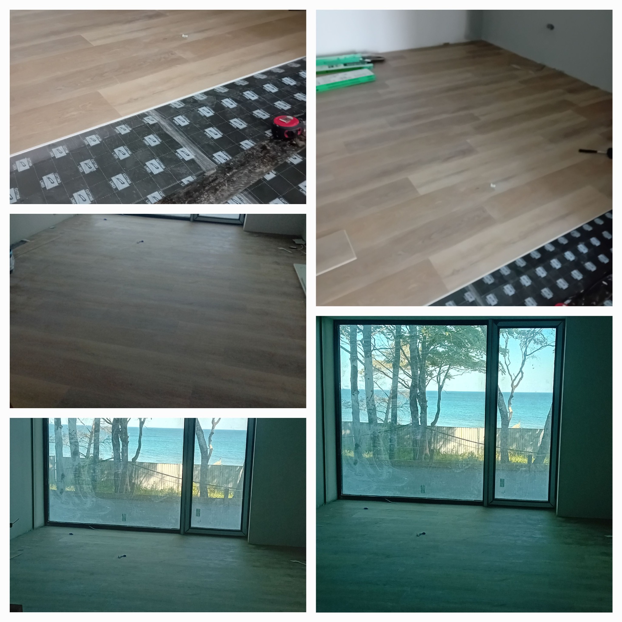 Podkład pod panele z widoczną taśmą mierniczą i fragmentem ułożonych jasnych paneli podłogowych, przez okno widok na morze i drzewa.