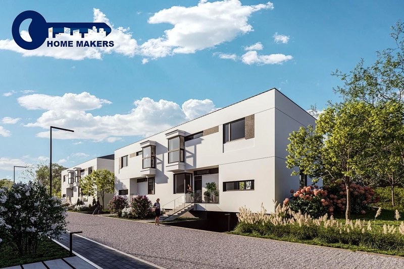Wizualizacja szeregu nowoczesnych, białych domów z płaskimi dachami, z logo firmy Home Makers w lewym górnym rogu, umieszczonych w zielonym otoczeniu z krzewami i drzewami.