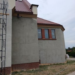 Nazar hulenchin - Budynek kościoła w trakcie prac elewacyjnych, z widocznym rusztowaniem, świeżo otynkowaną ścianą i fragmentem dachu z czerwoną dachówką.